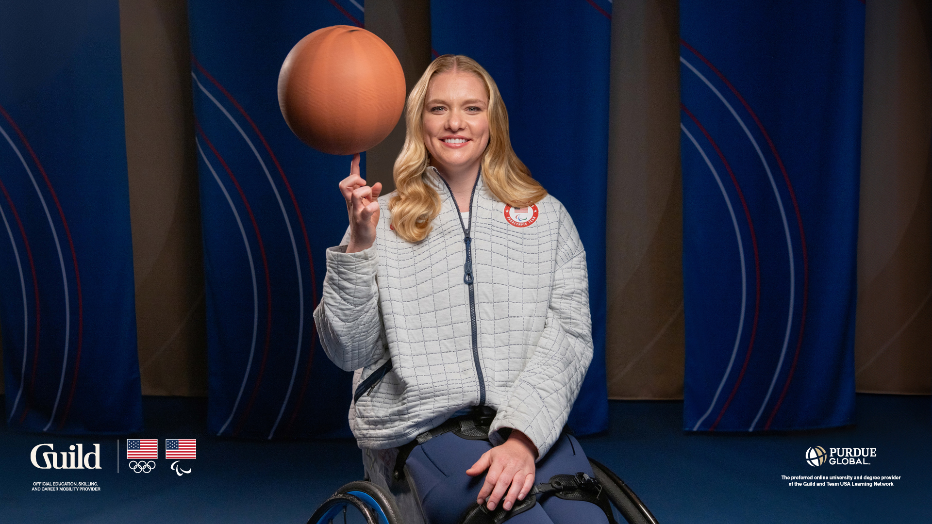 Rose Hollermann, wearing a Team USA jacket, is spinning a basketball on one finger and smiling.
