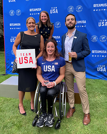 Julie Dussliere holds a Team USA sign at a team event in Paris. 