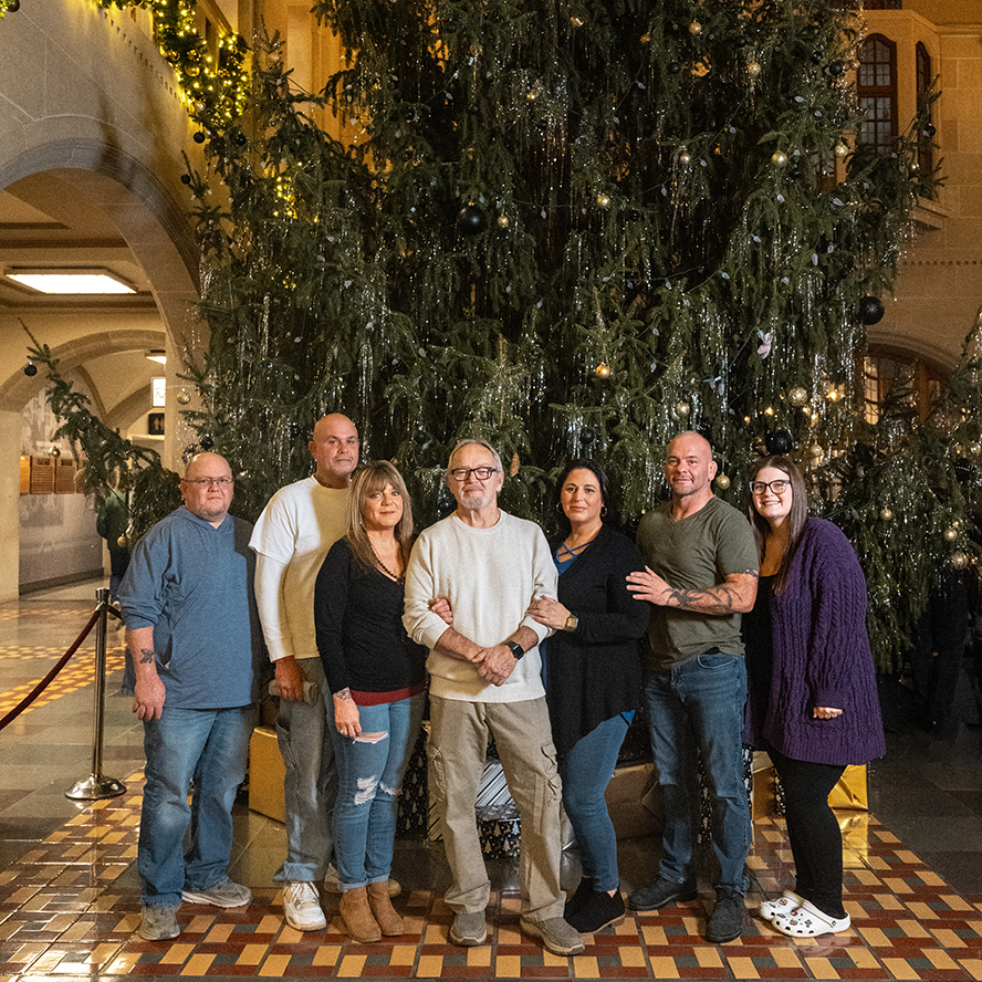 Darrell Smith and his family pose for a photo in front of the Purdue Memorial Union Christmas tree.