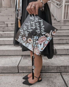 A close-up photo of Tara’s mortarboard, which reads “Set up to fail, but I chose to prevail.”
