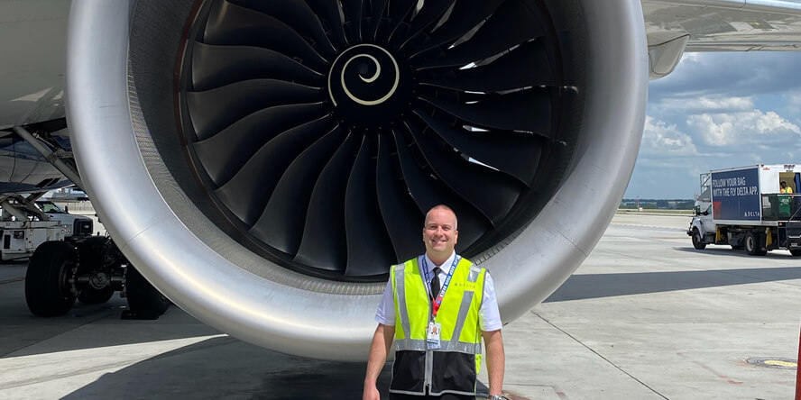 Greg Etter in front of a plane engine.