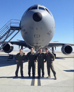 Greg Etter with crewmates in front of a plane.