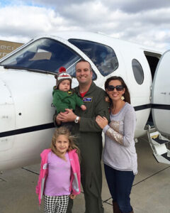 Greg Etter with his wife and two of their children in front of a plane.