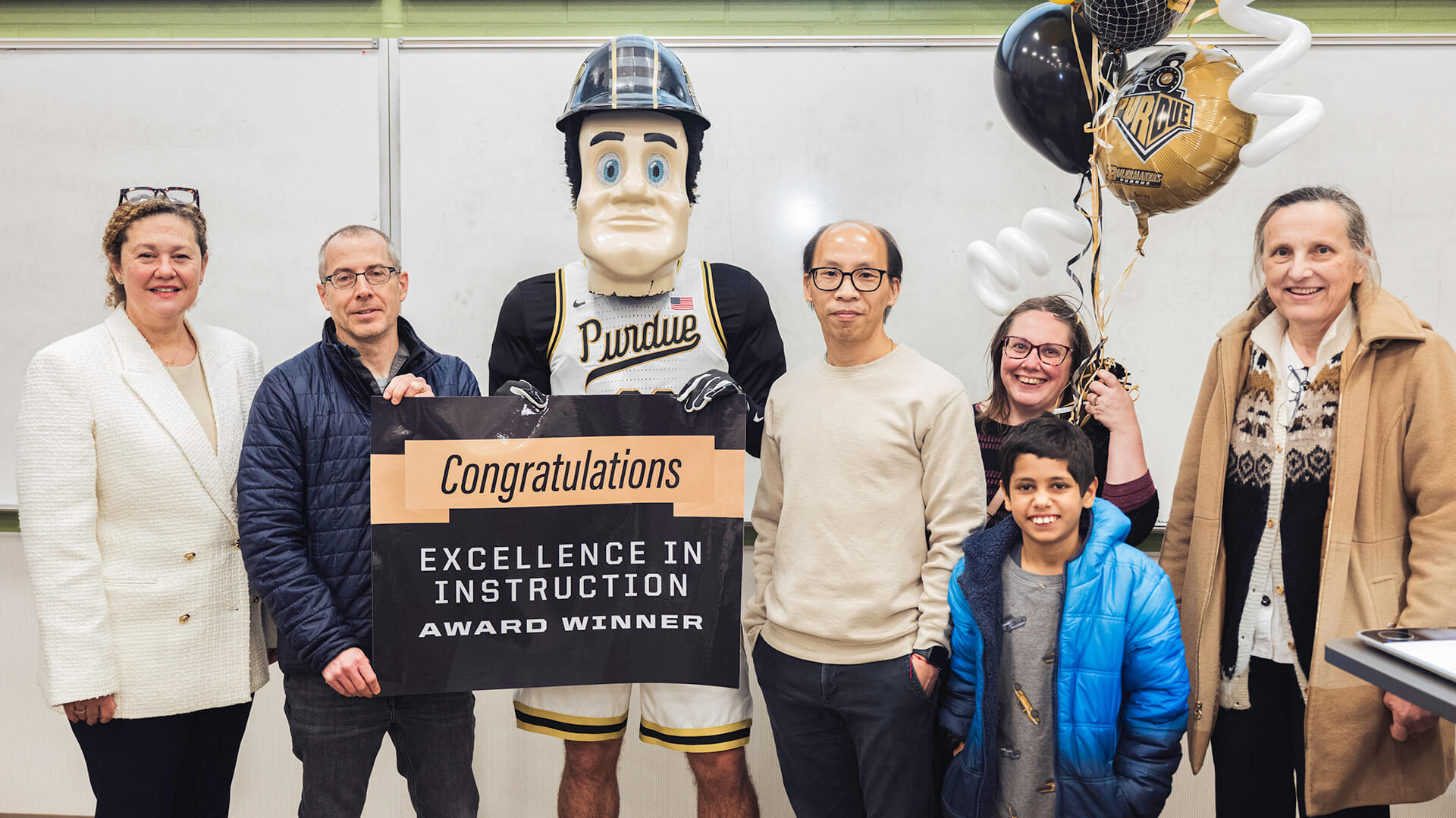 Purdue senior math lecturer Kuan-Hua “Joe” Chen poses with colleagues and friends in his classroom.