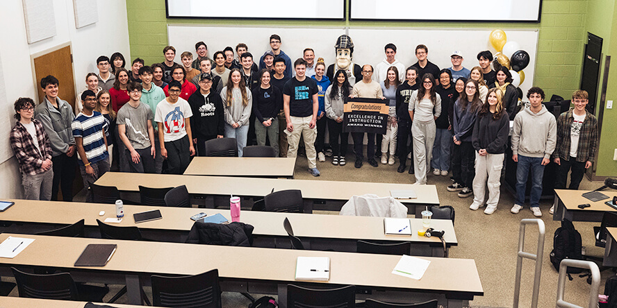 Purdue senior math lecturer Kuan-Hua “Joe” Chen stands with his students and Purdue Pete.