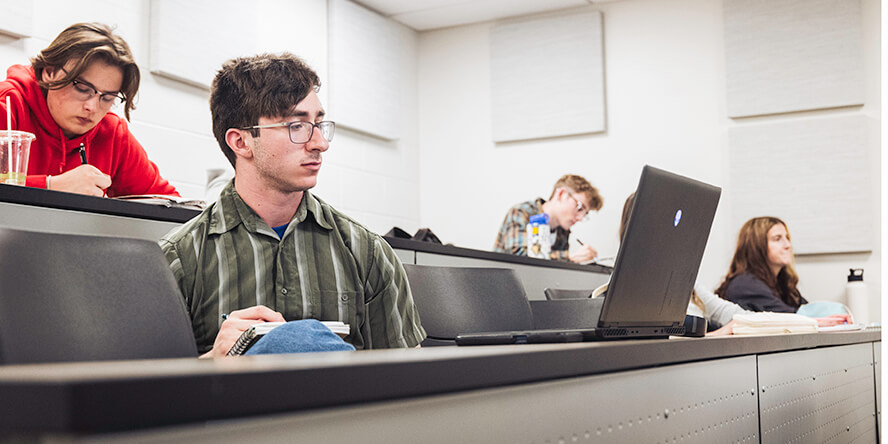 Purdue undergraduate students take notes during a math lecture.