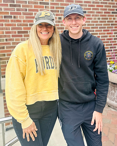 Leighellen and her son stand side by side wearing Purdue shirts and baseball hats.
