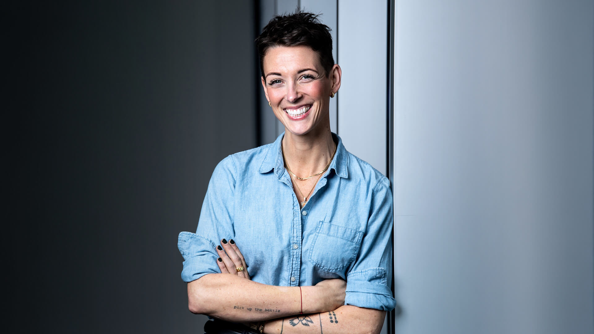 Kara Allen poses with her arms crossed and smiles into the camera.