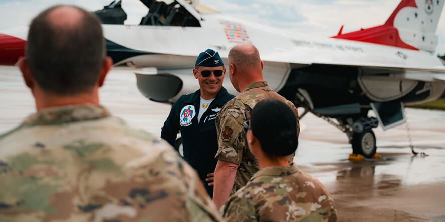 Nathan Malafa greeting military members on a tarmac.