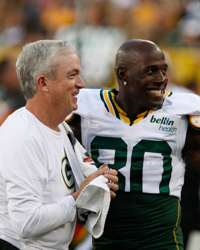 Green Bay Packers athletic trainer Pepper Burruss and receiver Donald Driver chat on the sidelines.