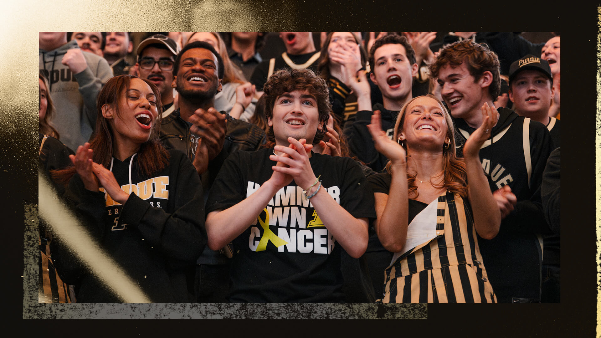 Andrew Kinder wears a Hammer Down Cancer T-shirt and cheers from the crowd at Mackey Arena.