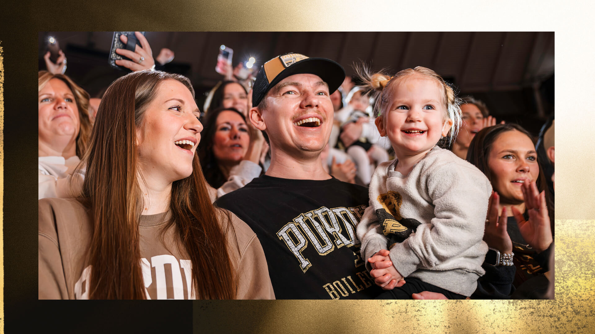 Two-year-old Callie Cochran is cradled in her dad’s arms, who’s standing next to her mom.