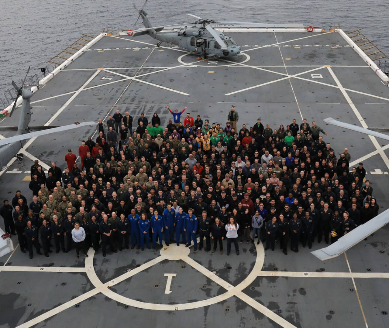 Members of the Artemis recovery team gather for a photo on the deck of the USS John P. Murtha