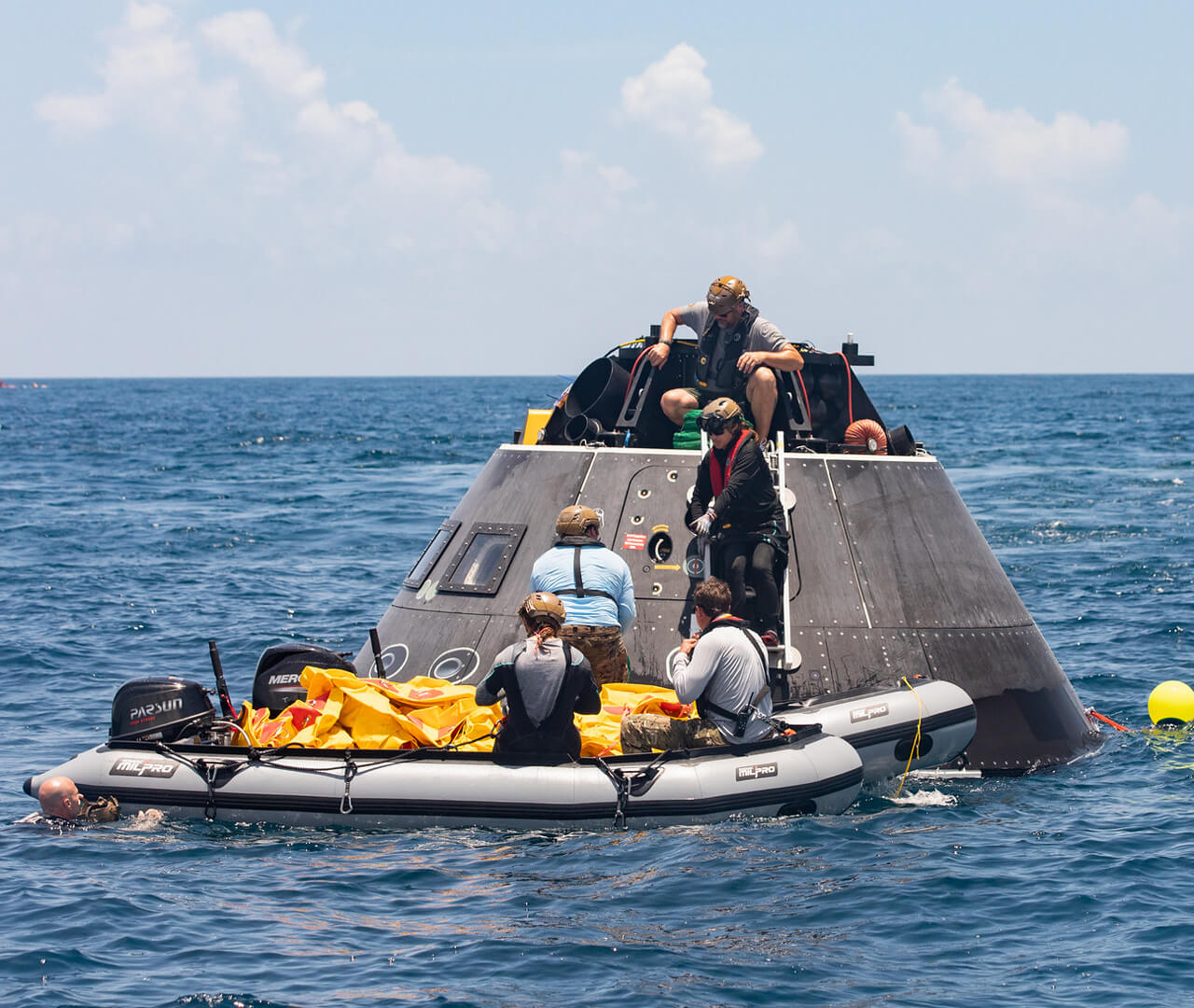 A training exercise where recovery team practices a water recovery with an Artemis Orion crew module test article