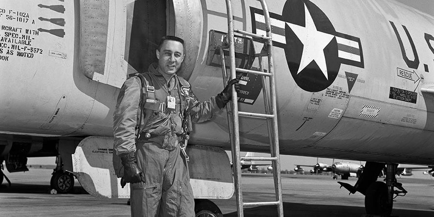 Gus Grissom stands next to a U.S. Air Force plane