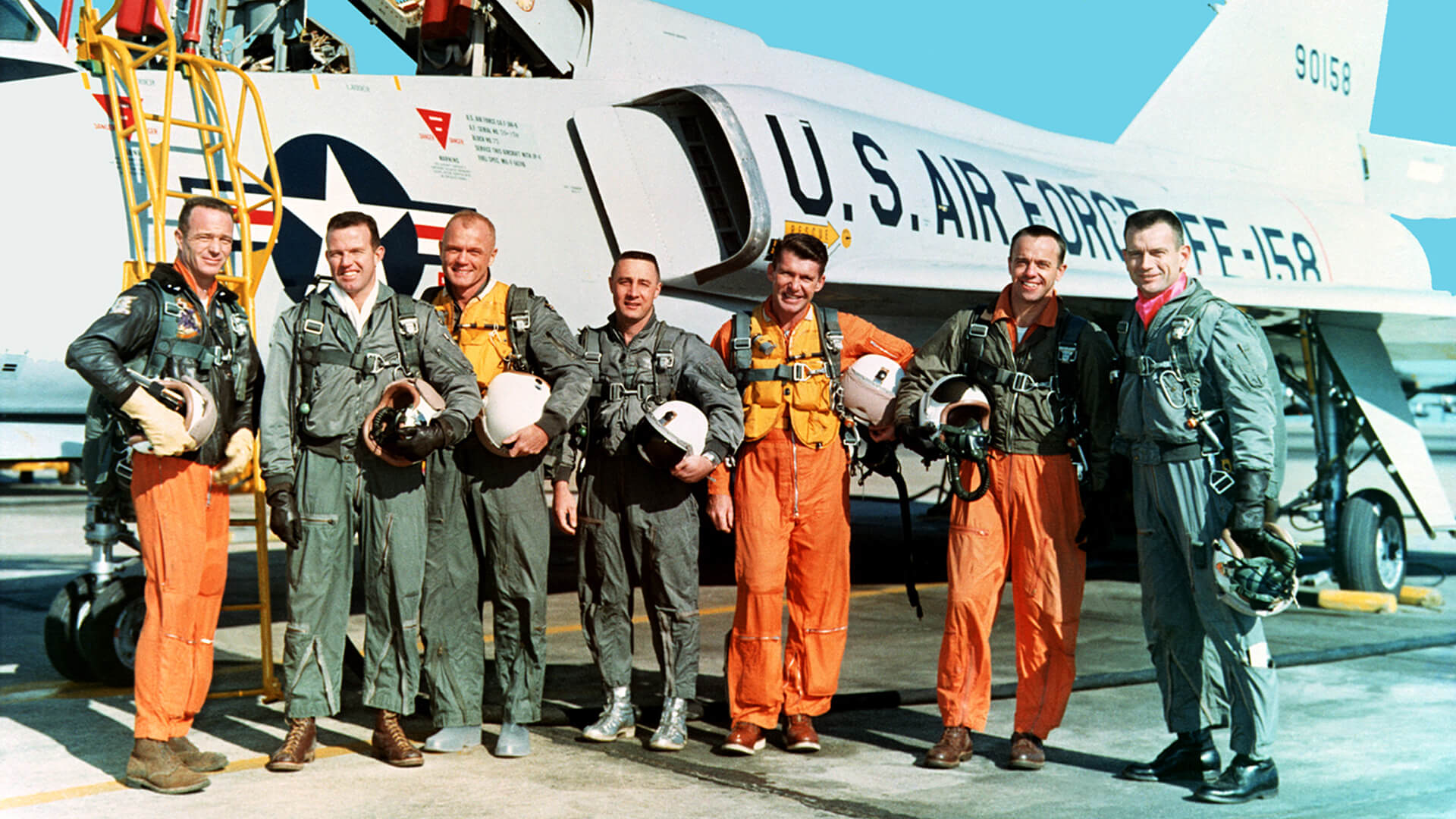 America’s first seven astronauts, the Mercury Seven, stand in front of an Air Force jet