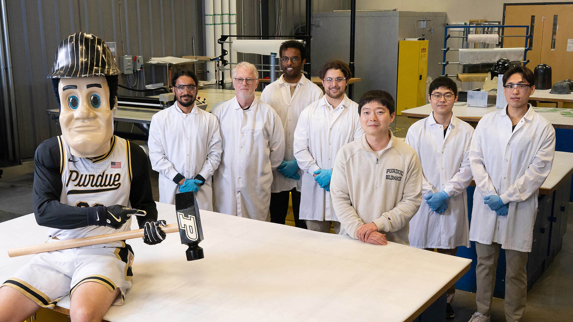 Students and faculty stand alongside sports mascot Purdue Pete in Purdue’s Raisbeck Advanced Composites Laboratory, where Purdue Pete’s head is made