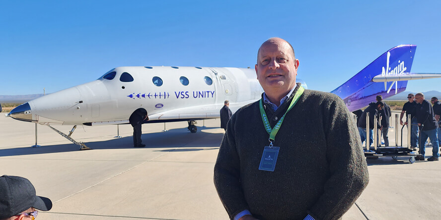 Steven Collicott stands near Virgin Galactic’s VSS Unity spaceplane at Spaceport America