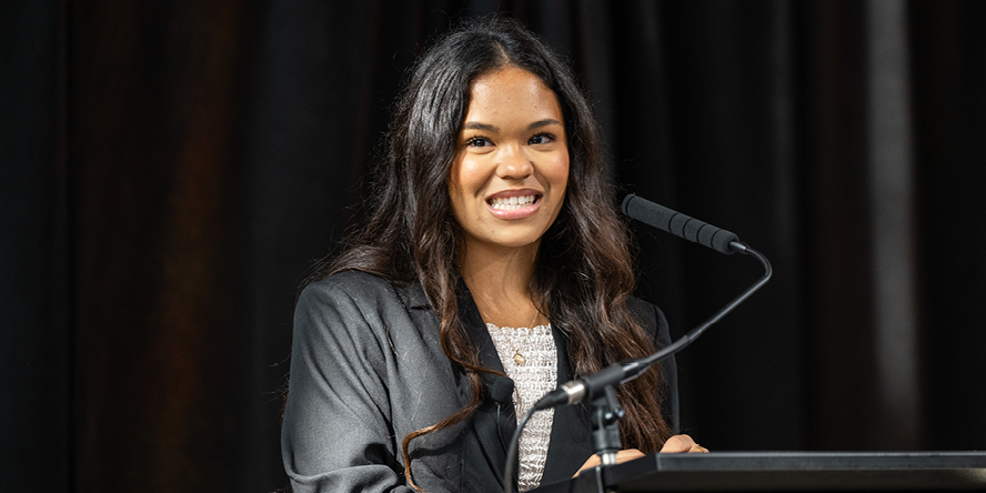 Purdue graduate student Abigail Mizzi speaks into a microphone at a podium