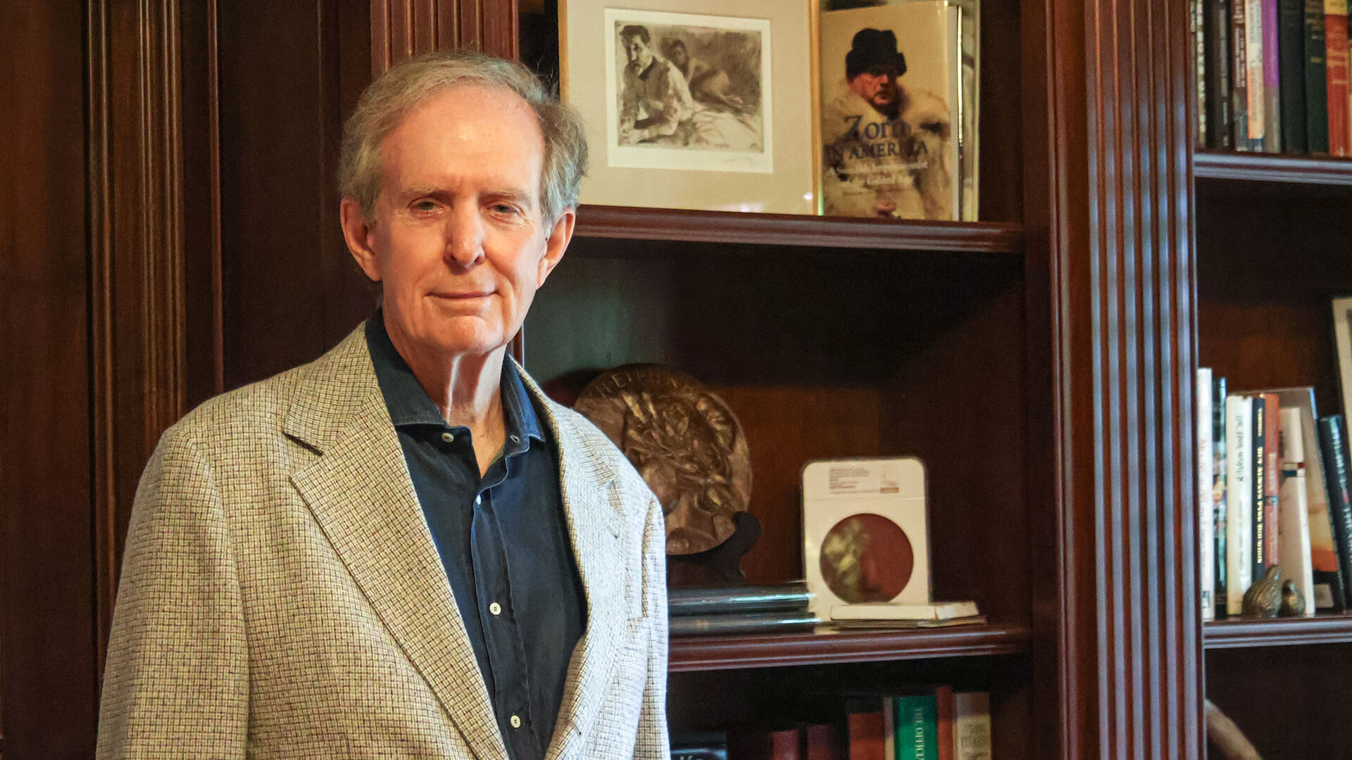 Michael Moran standing in front of bookshelves.