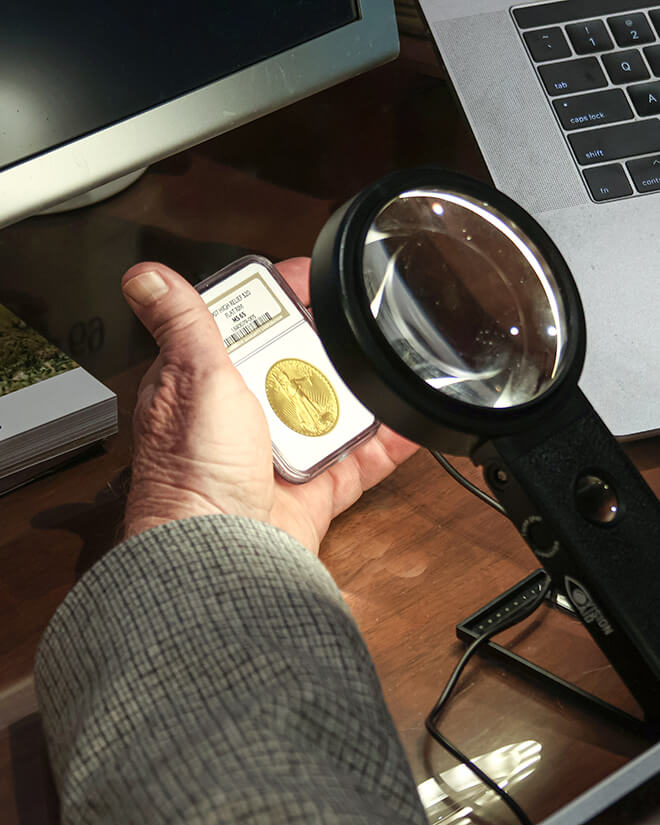 Michael Moran taking a closer look a coin.