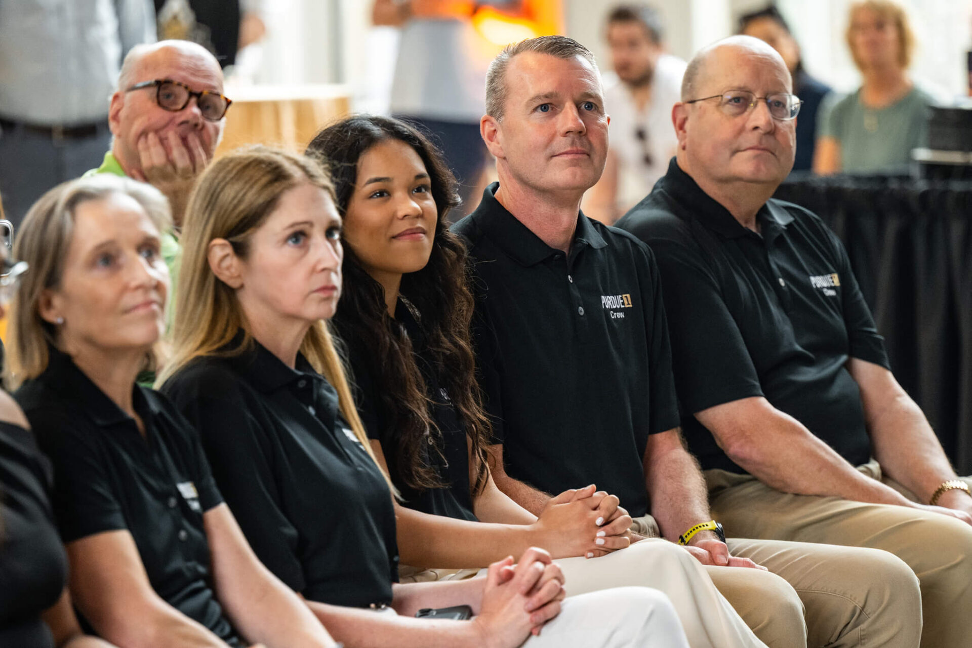 The members of the Purdue 1 crew sit together in the front row at a press conference