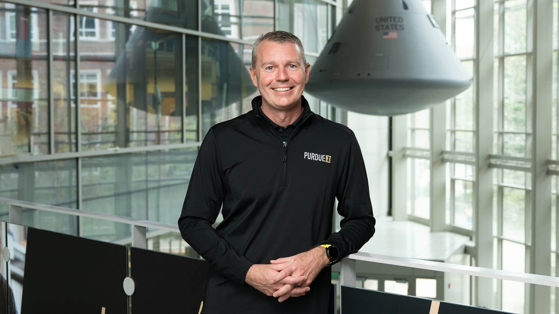 Jason Williamson leans against a railing in the atrium of Purdue’s Neil Armstrong Hall of Engineering