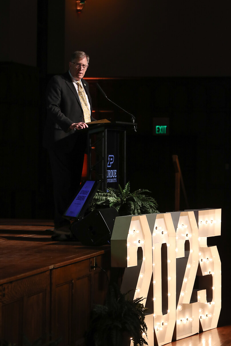 Dan Dumbacher speaks at a podium 