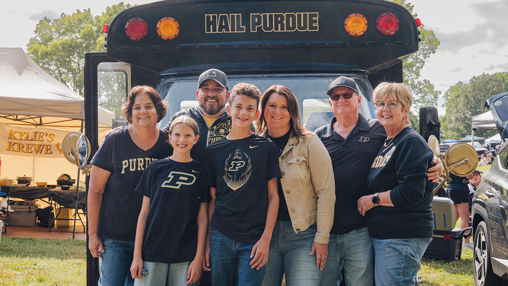 The Vandewalle family standing in front of their bus.